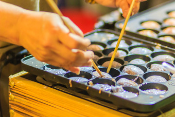 Vendor is cooking for Khanom khrok or coconut-rice pancakes, one of the ancient Thai desserts.