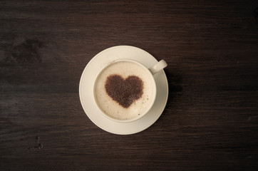 Coffee cup with heart shape cinnamon on wood background. Valentine's concept