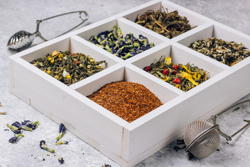 Assortment of dry tea in white wooden box.