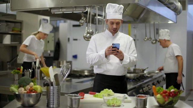 chef preparing salad then good news on smartphone