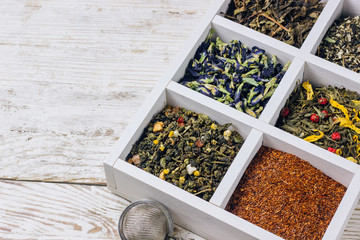 Assortment of dry tea in white wooden box.