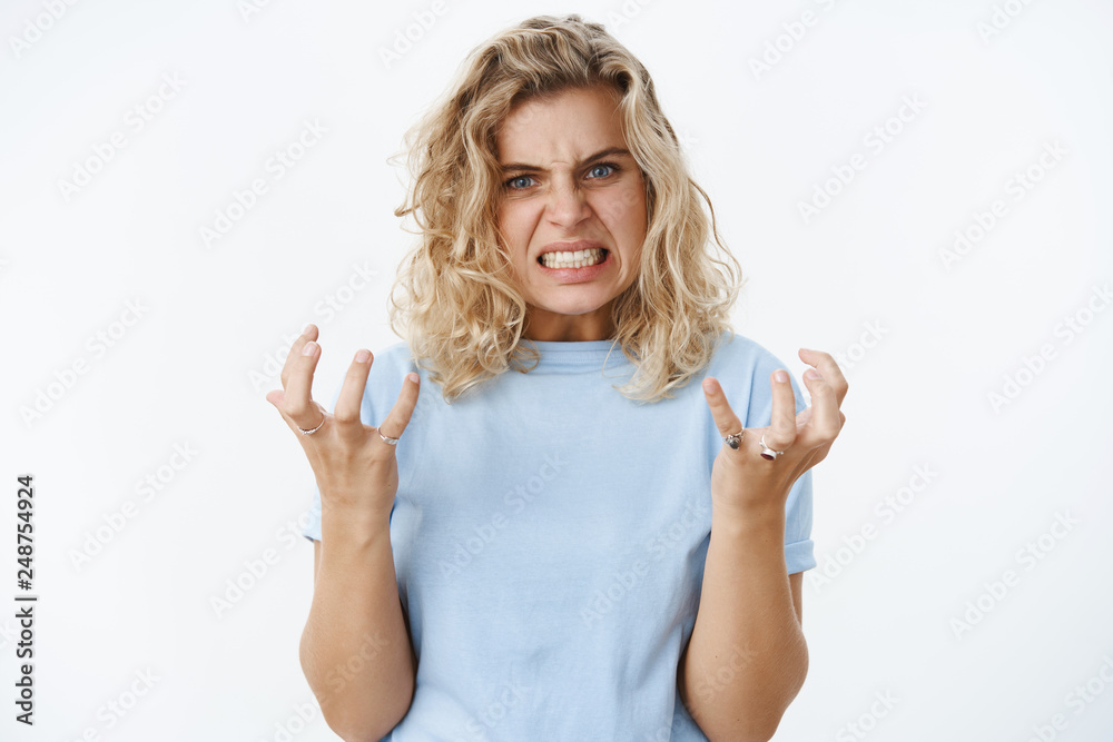 Wall mural Girl gonna blow out over anger and distress clench teeth and fists in fury and dismay frowning being pressured and distressed full of hate, looking angry at camera over white background - Wall murals