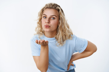 Catch my kiss. Portrait of cute and sensual young 25s woman with blond hair and blue eyes bending...