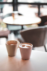 two cups of coffee with milk. cake and people in cafe concept.