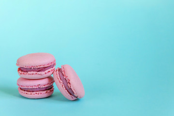 Sweet almond colorful unicorn pink macaron or macaroon dessert cake isolated on trendy blue pastel background. French sweet cookie. Minimal food bakery concept. Copy space