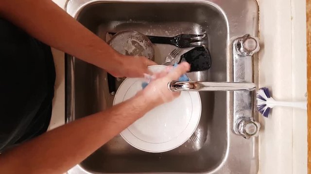 Man washing a plate in a sink