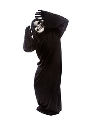 Halloween costume of a skeleton grim reaper wearing a black robe on a white background acting...