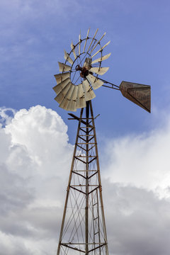 Windmill with blue sky and clouds in background