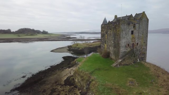 Aerial parallax around the beautiful and historical Castle Stalker, on the picturesque Loch Laich, Scotland