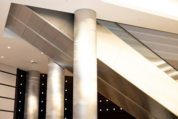 Naklejka premium Escalator in the hall, installed between the columns. Modern technologies in the construction of buildings.