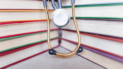 Medical student multicolor textbook and stethoscope. Collection of scientific papers