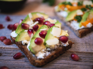 Delicious and healthy avocado toast with pomegranate, bell pepper and almond
