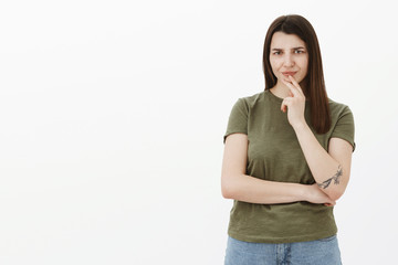 Girl not liking what hears, frowning and wrinkling nose from dislike and confusion holding hand...