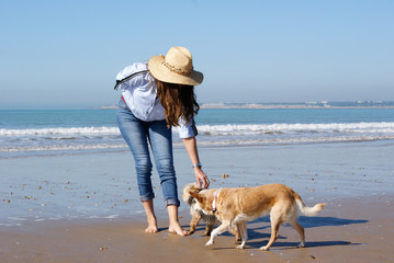 Young girl walking around the beach with her dogs in Puerto de Santa María,Andalucía,Spain