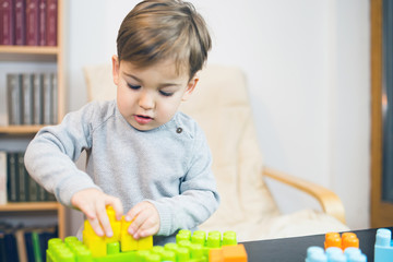 Little boy playing at the table at home