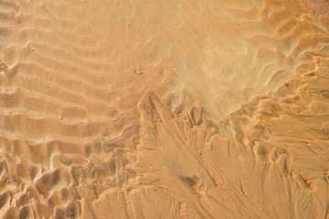 Close-up Fine beach sand dunes in the summer sun smooth texture as background. Aerial top drone view