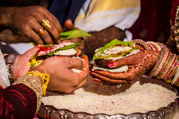 Bride and Groom Offer Rice as a Symbol of Plenty at a South Indian Wedding Ceremony Wedding in...
