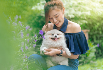 Woman hug with pomeranian dog in garden