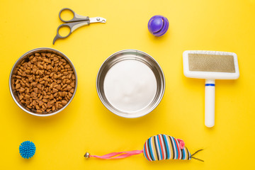 Pet, cat, food and accessories of cat life flat lay, on a yellow background. Background for design.