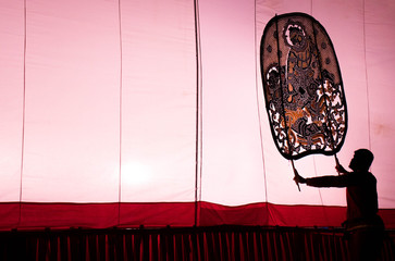 A man is playing an old Thai traditional shadow play called as Nang Yai,Composed to Violet tone.