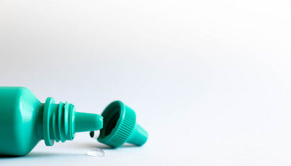 Green plastic eye dropper bottle isolated on white background.