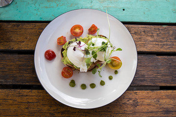 Smashed Avocado and Poached Eggs with cherry tomatoes