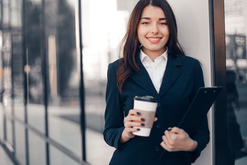 Obraz premium Successful smiling businesswoman or entrepreneur drink coffee in front of his office.