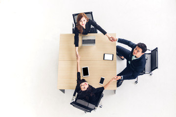 Top view of successful of group business people holding their hands together on wooden desk at...