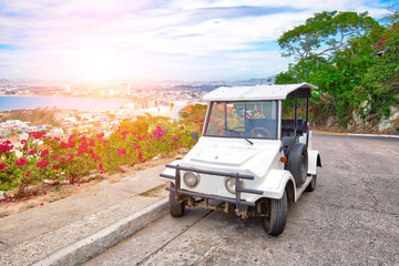 Obraz premium Pulmonia taxi with panoramic view of the Mazatlan Old City in the background, Mexico
