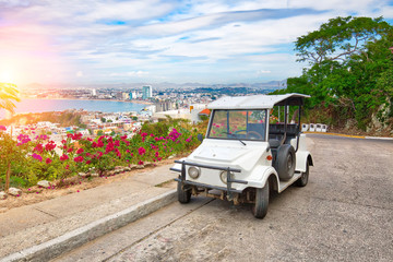 Fototapeta na wymiar Pulmonia taxi with panoramic view of the Mazatlan Old City in the background, Mexico