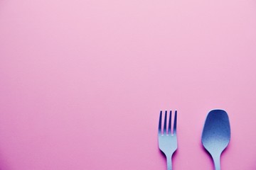 Plastic Blue Spoon and Fork On Pink Background