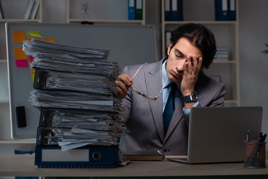 Young Male Employee Working Late At Office