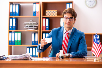 Fototapeta na wymiar Young handsome politician sitting in office
