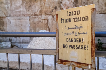 Sign saying "Danger! No Passage!" in three languages