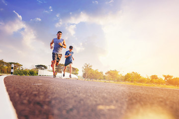 Fit men running sprinting along the road. Fit male fitness runner during outdoor workout