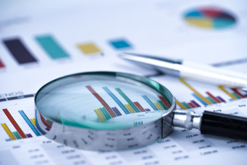 Magnifying glass on charts graphs spreadsheet paper. Financial development, Banking Account,...