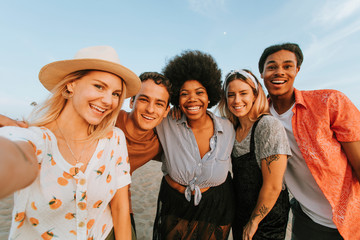 Group of diverse friends taking a selfie at the beach