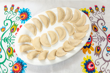 Pierogi laid out on a plate ready for boiling