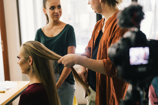 Hair stylist busy working with a model