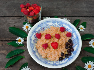 Bowl of oatmeal porridge with fresh strawberries and raspberries.Healthy breakfast. Flat lay, top view, copy space. Morning healthy breakfast.Close up. Healthy food, healthy breakfast concept.