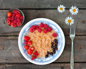 Bowl of oatmeal porridge with fresh strawberries and raspberries.Healthy breakfast. Flat lay, top view, copy space. Morning healthy breakfast.Close up. Healthy food, healthy breakfast concept.