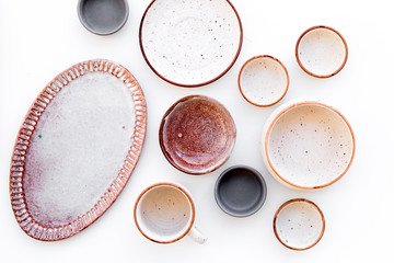 Kitchen concept. Crockery kit. Empty ceramic plates and mugs on white background top view
