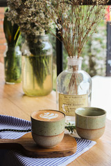 Latte coffee mug placed on a wooden table in a coffee shop