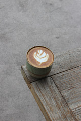 Latte coffee mug placed on a wooden table in a coffee shop