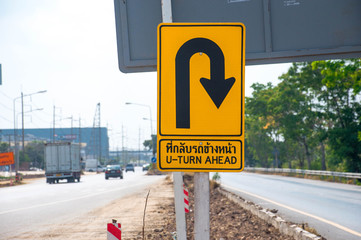 In the middle of the road A yellow  turn around sign