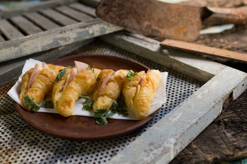 Croissant cheese in wooden dish placed on a rusty grill