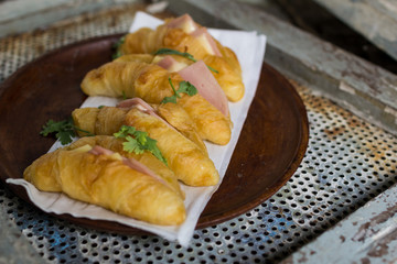 Croissant cheese in wooden dish placed on a rusty grill