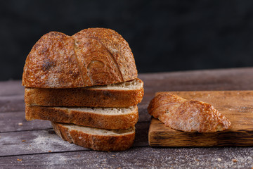 Slices of fresh homemade bread on a wooden table close up. The concept of healthy food and traditional bakery.
