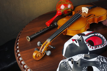 Violin, flute, theatrical masks, tambourine, maracas.