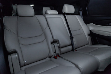 Сlose-up of the car  interior:  white leather rear seats and seat belts .